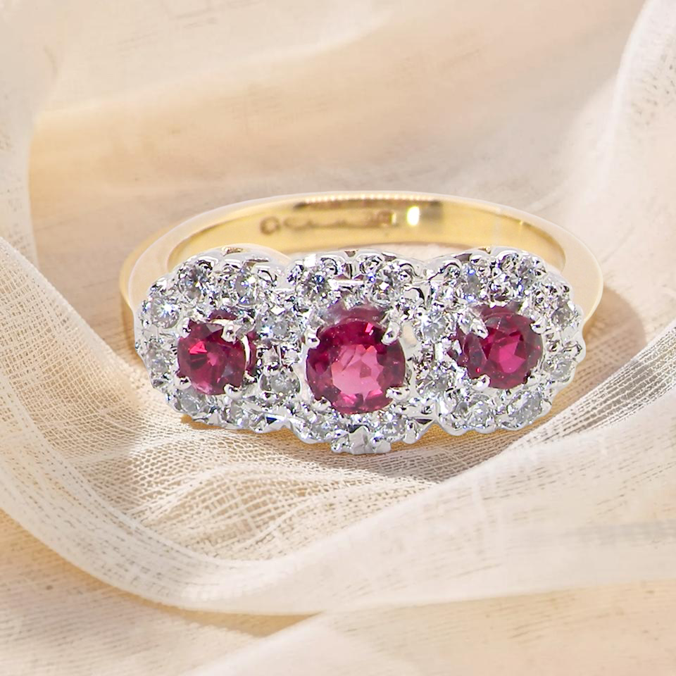 A striking triple cluster ring crafted in 18 carat gold, dating circa 1990–2000, and fully hallmarked in the UK.