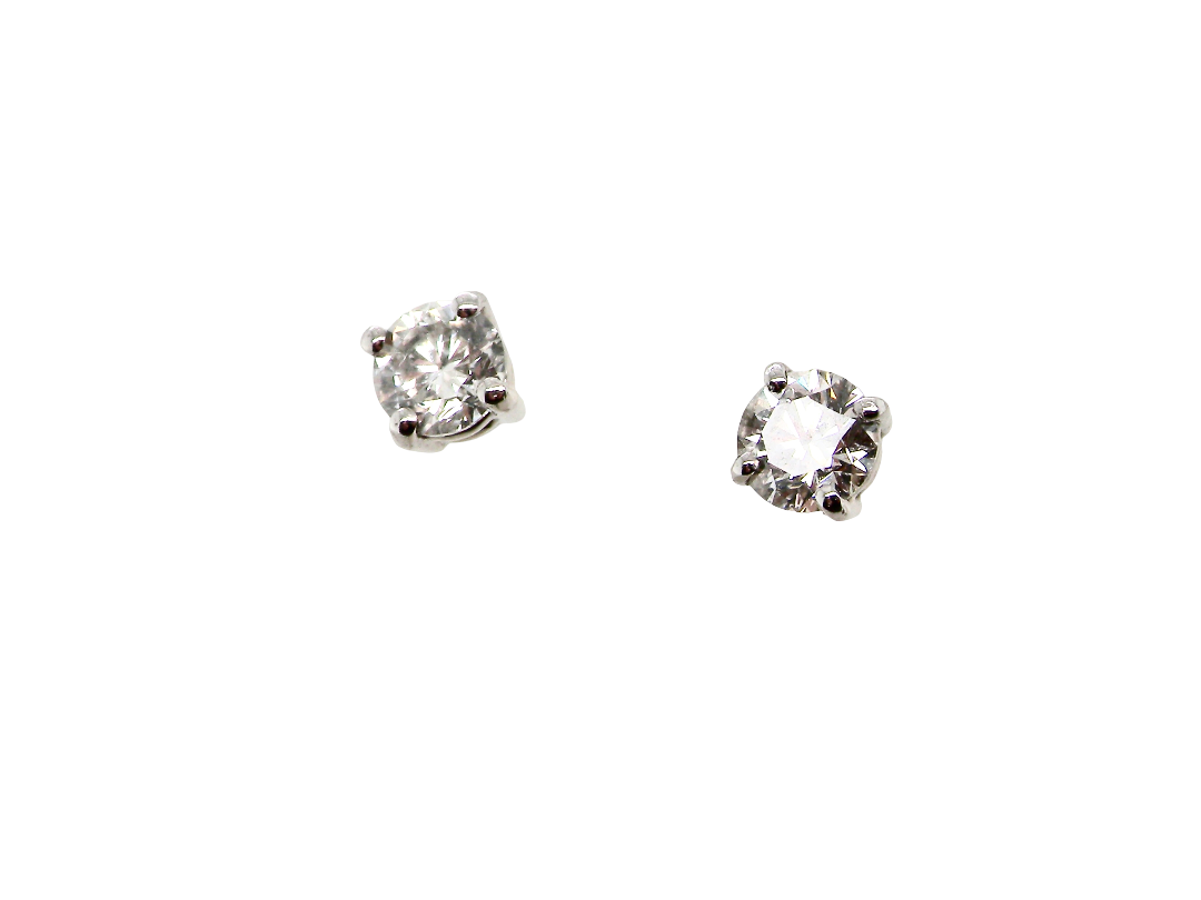 A pair of round-cut solitaire stud earrings in a silver-toned setting, displayed on a solid white background.