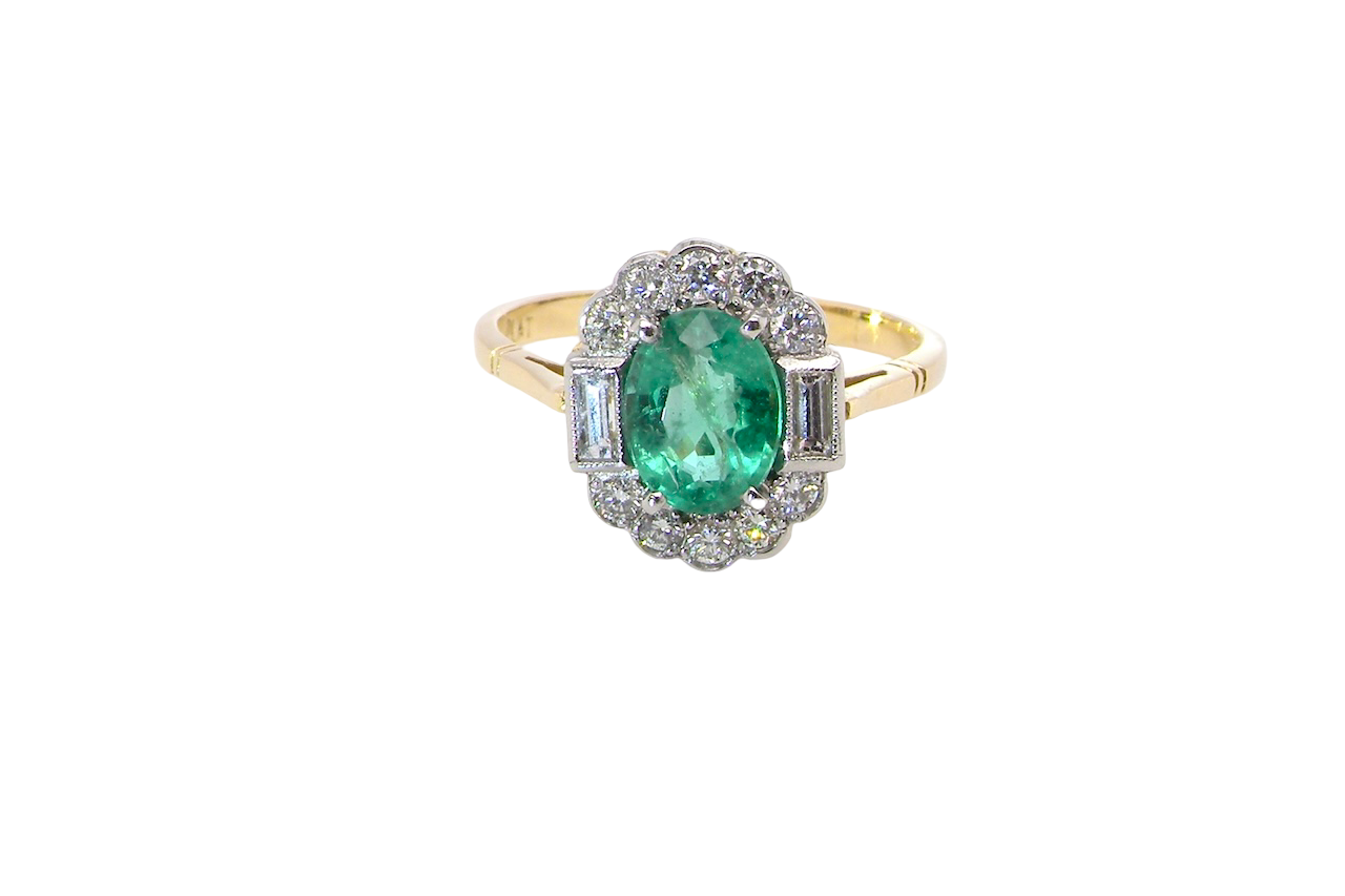 A stunning vintage cluster ring, set with an oval-cut emerald measuring 8 x 6mm, approximately 1.10 carats. The emerald displays a rich, deep grass-green colour with natural inclusions, typical of a genuine stone.