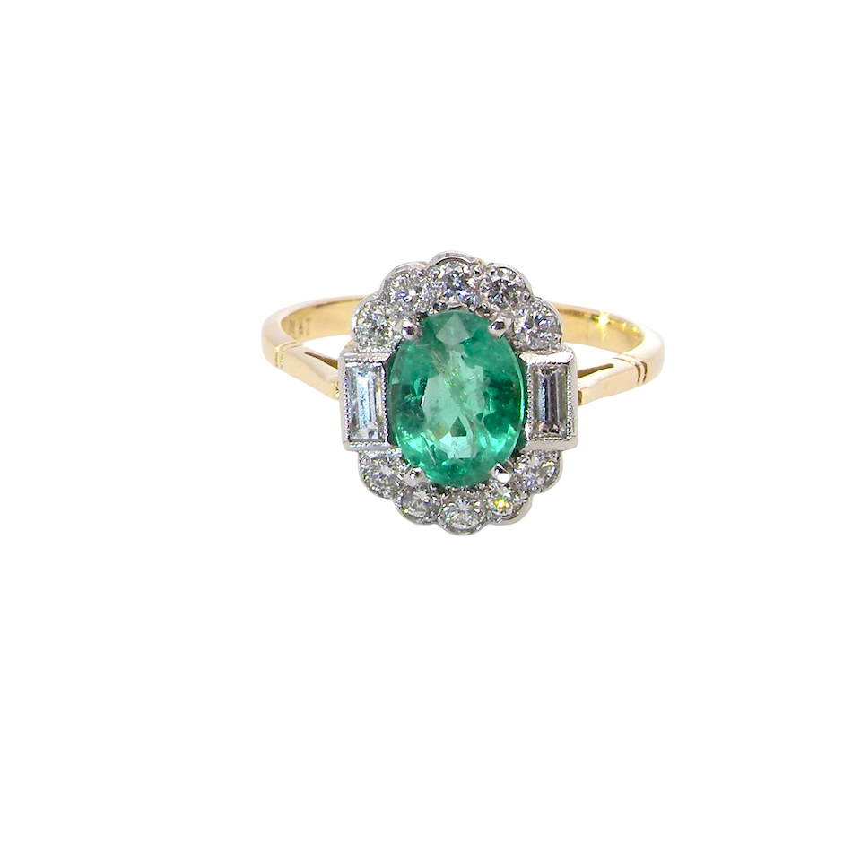 A stunning vintage cluster ring, set with an oval-cut emerald measuring 8 x 6mm, approximately 1.10 carats. The emerald displays a rich, deep grass-green colour with natural inclusions, typical of a genuine stone.