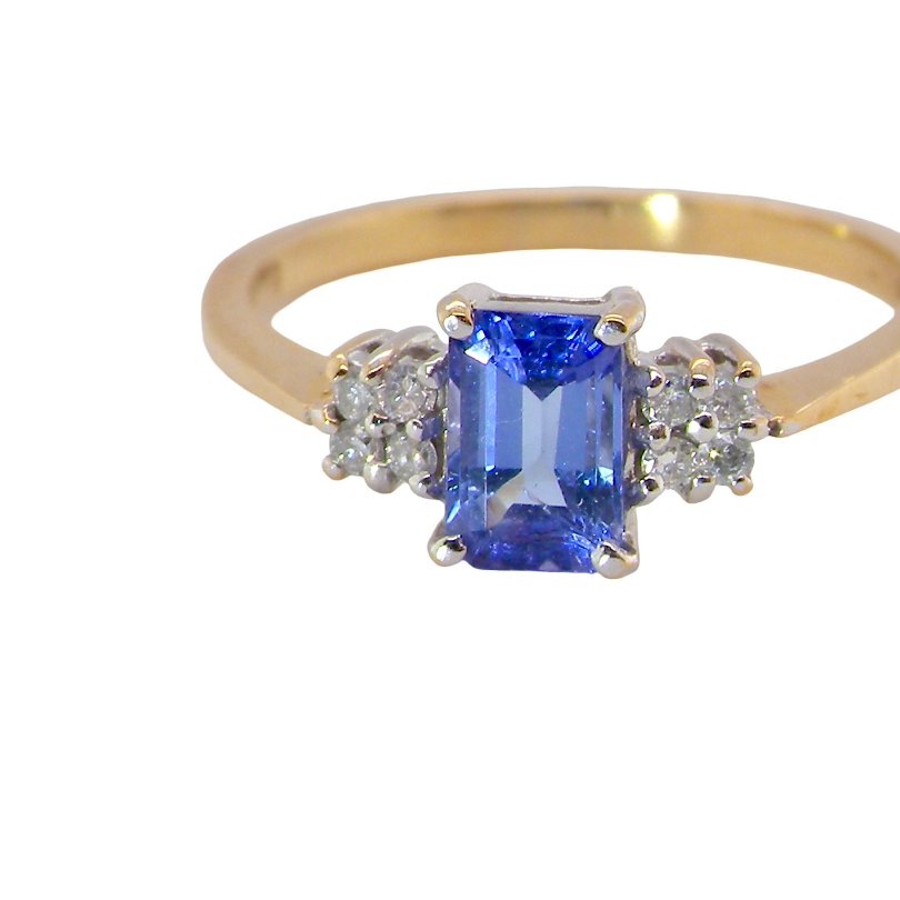A three stone 18 carat gold ring. Features a rectangular tanzanite centre stone (est 0.50 carats)