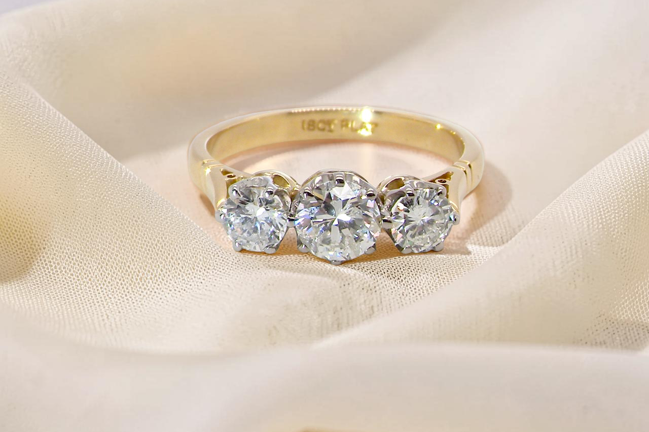 A three stone trilogy ring. The diamond centre stone measures 5.5mm (est 0.60 carats) each side a 4mm diamond estimated at 1.10 carats.