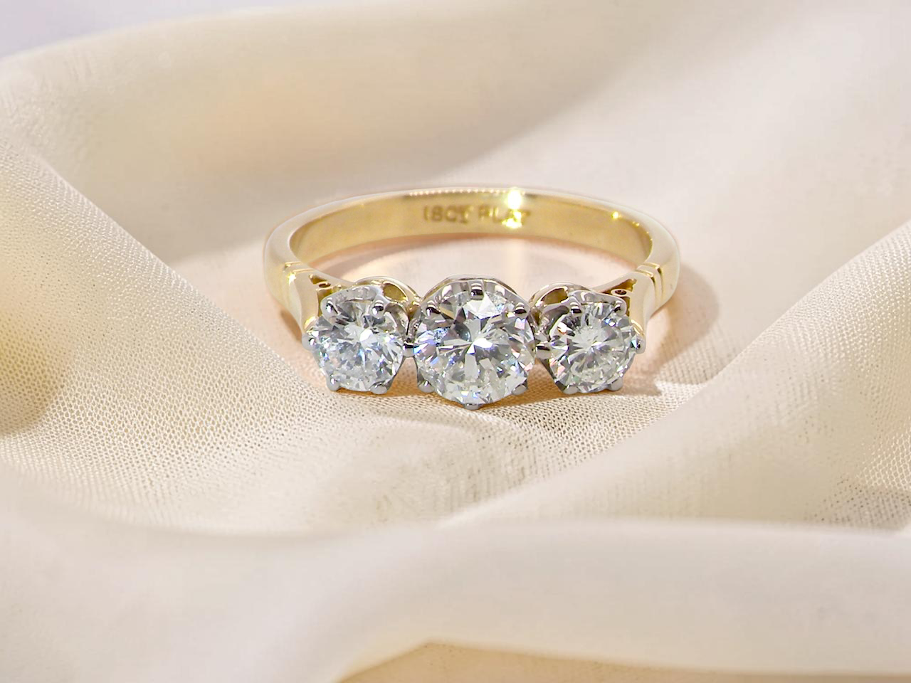 A three stone trilogy ring. The diamond centre stone measures 5.5mm (est 0.60 carats) each side a 4mm diamond estimated at 1.10 carats.