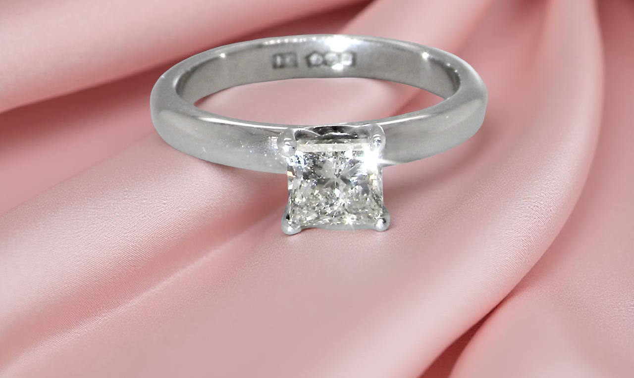 A timeless and beautifully crafted solitaire ring featuring a stunning 0.78 carat Princess white diamond