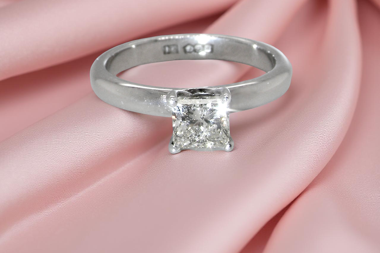 A timeless and beautifully crafted solitaire ring featuring a stunning 0.78 carat Princess white diamond