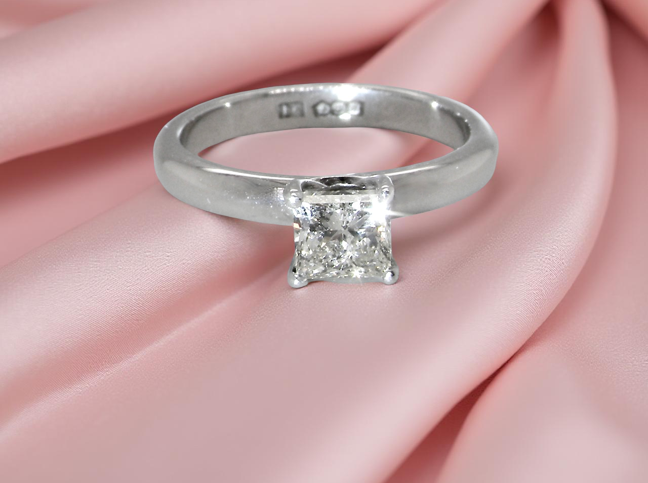A timeless and beautifully crafted solitaire ring featuring a stunning 0.78 carat Princess white diamond
