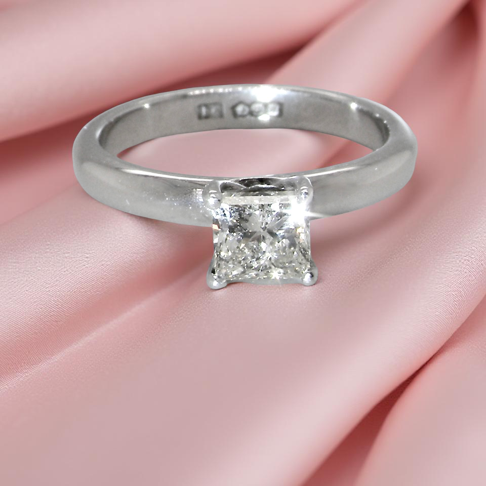 A timeless and beautifully crafted solitaire ring featuring a stunning 0.78 carat Princess white diamond