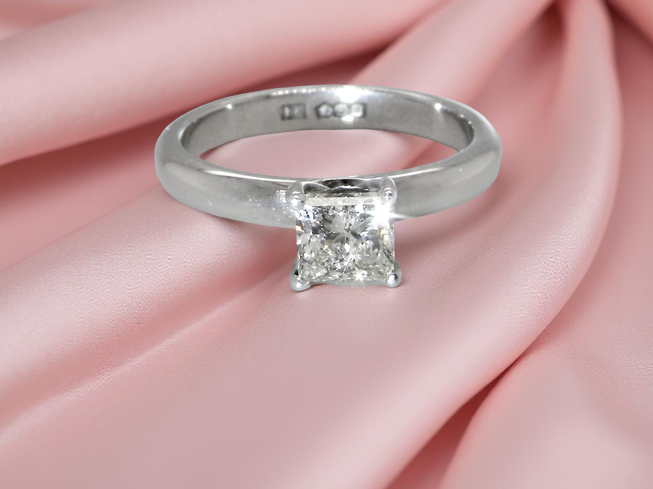 A timeless and beautifully crafted solitaire ring featuring a stunning 0.78 carat Princess white diamond
