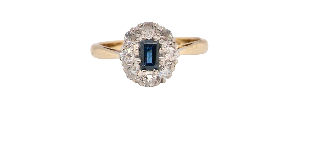 A traditional 1970s cluster ring featuring a rectangular-cut sapphire,