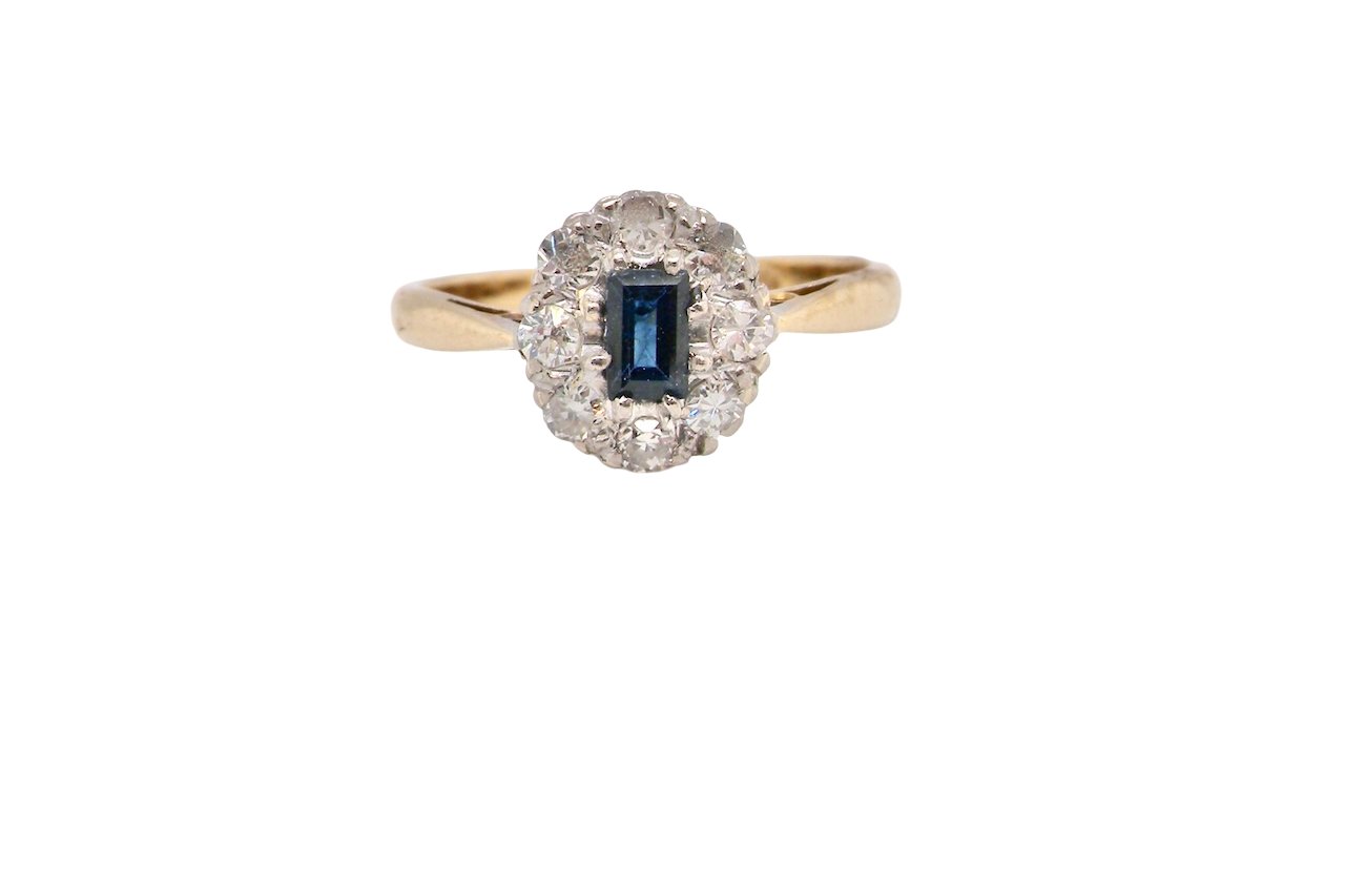 A traditional 1970s cluster ring featuring a rectangular-cut sapphire,