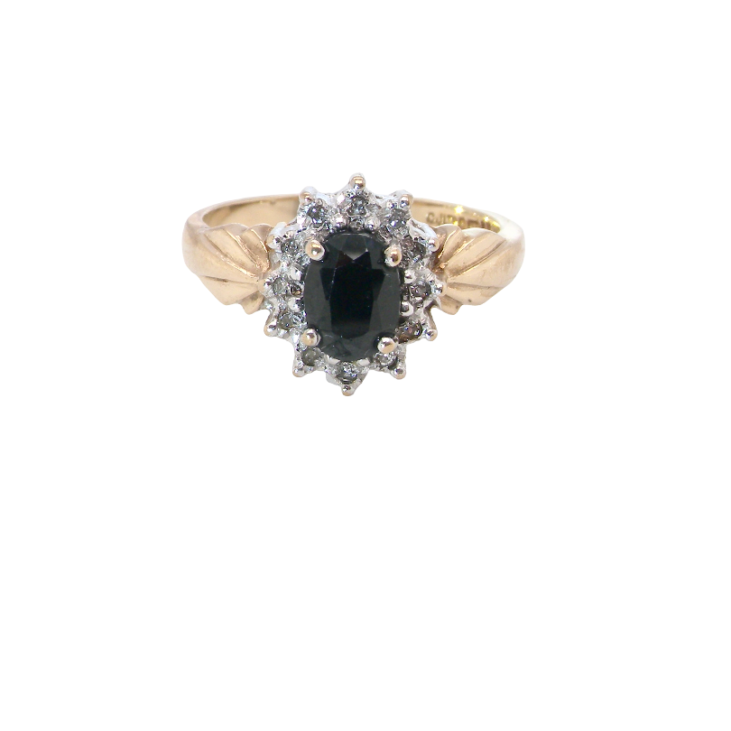 A traditional cluster ring that features to the centre a dark black blue oval cut sapphire 7x5mm (est 3/4 ct) claw set.