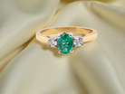 A traditional three stone Emerald and Diamond ring