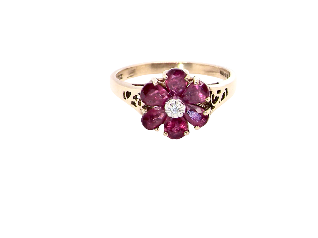 A very pretty 9 carat gold cluster ring. The centre stone a small illusion set diamond, 1.3mm
Surrounded by six pear shaped red rubies,
