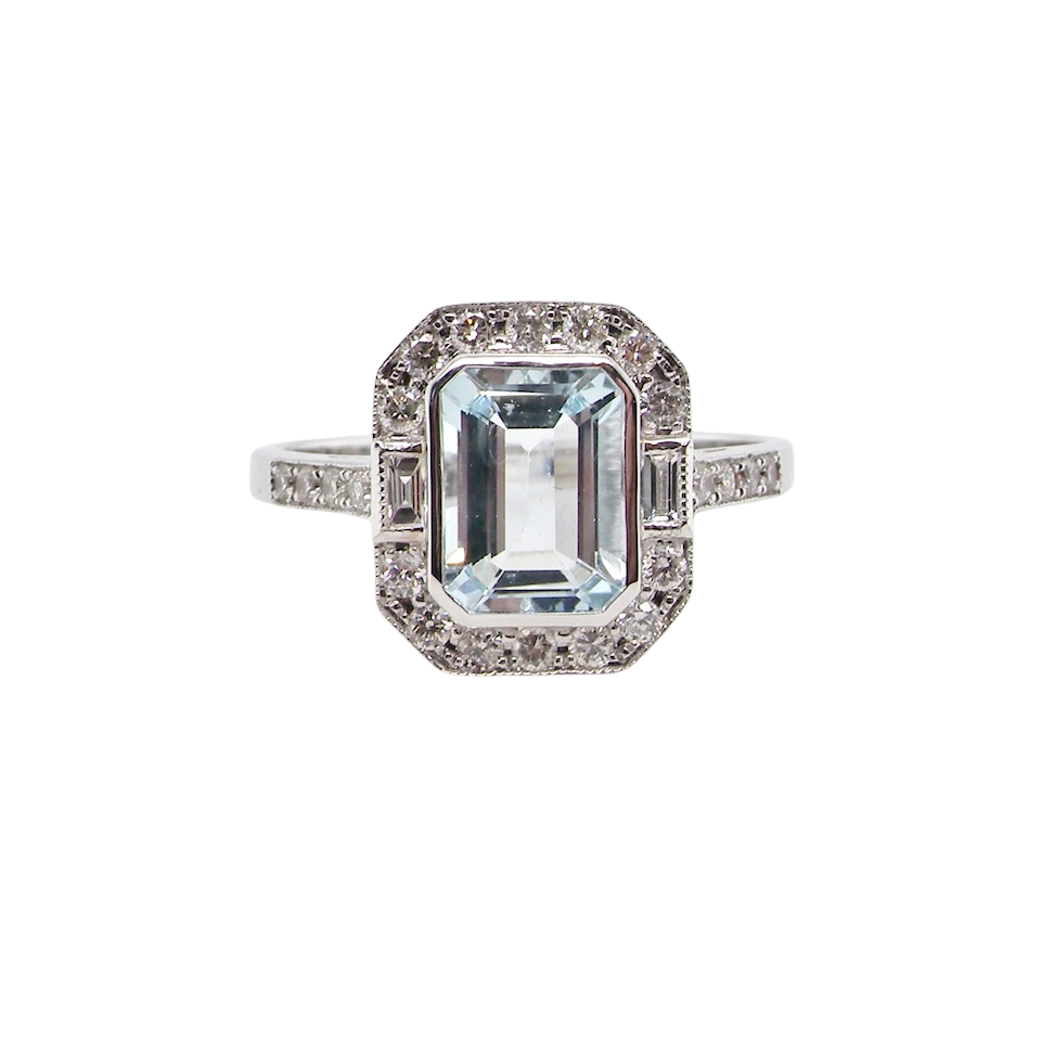 A very pretty cluster ring. Features a step cut aquamarine centre stone, 8x7mm (est 1.21 carats). Plain rim setting.