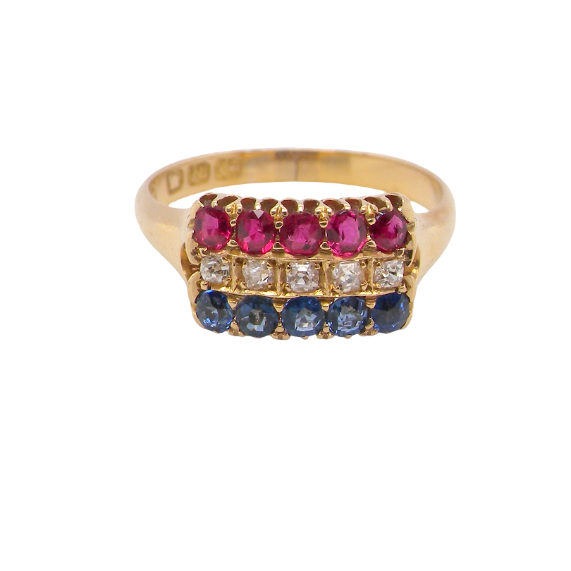 A yellow gold ring featuring three rows of round-cut gemstones: a top row of vibrant pink rubies, a middle row of clear diamonds, and a bottom row of deep blue sapphires, set against a plain white background.
