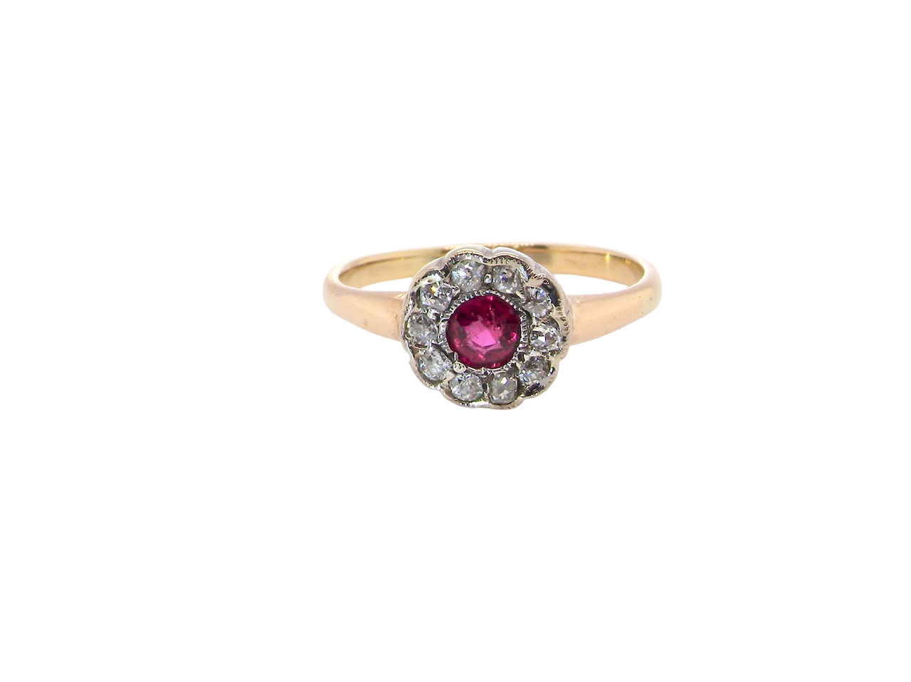 A very pretty vintage daisy cluster ring. Features to the centre a round pink red ruby that measures 4mm, and is mille grain set.