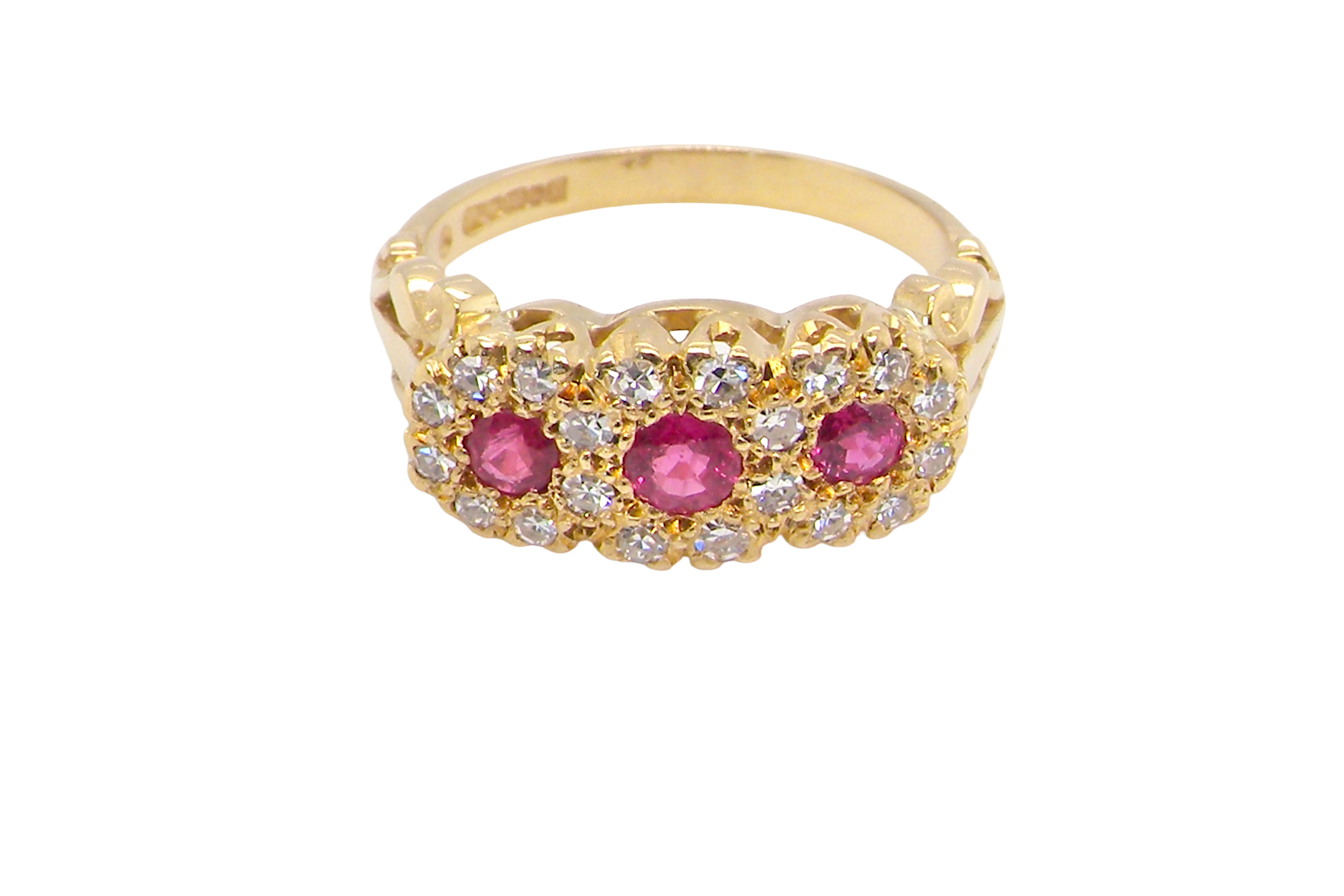 Gold ring with pink gemstones and diamonds on a white background