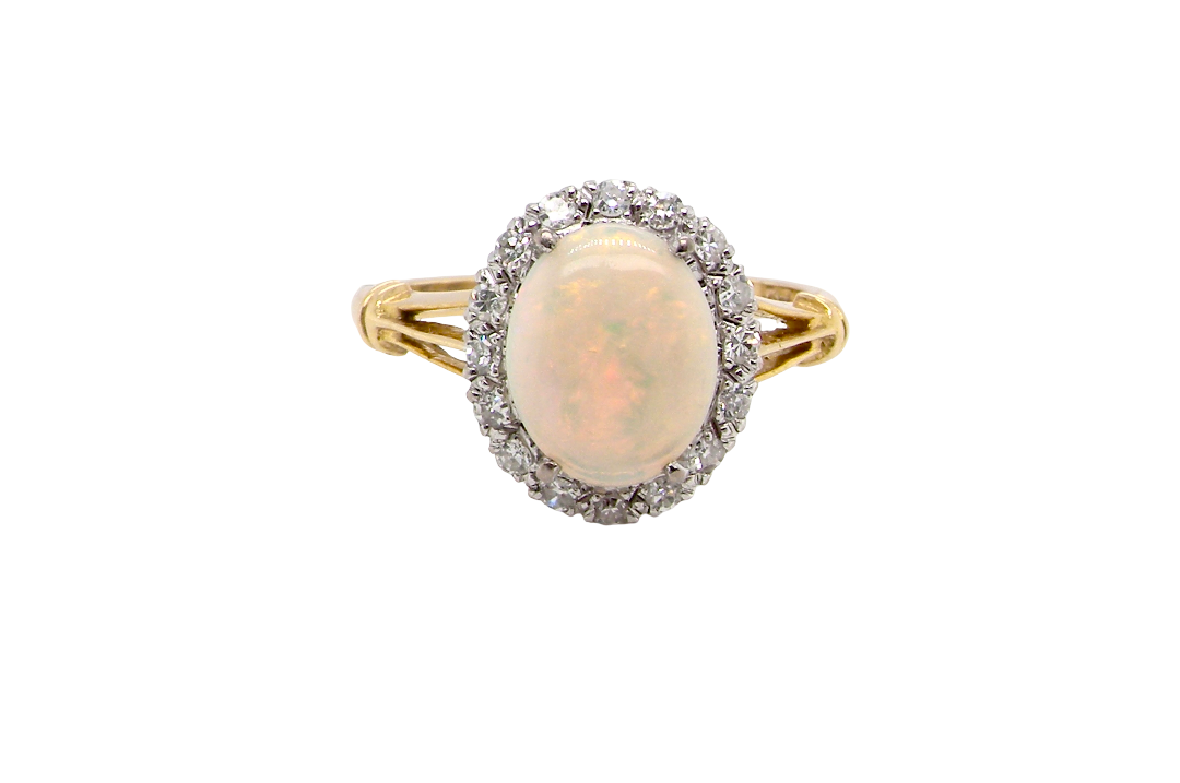 A vintage cluster ring. Features an oval white opal, measures 10x8mm, with a