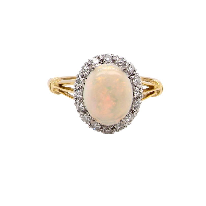 A vintage cluster ring. Features an oval white opal, measures 10x8mm, with a