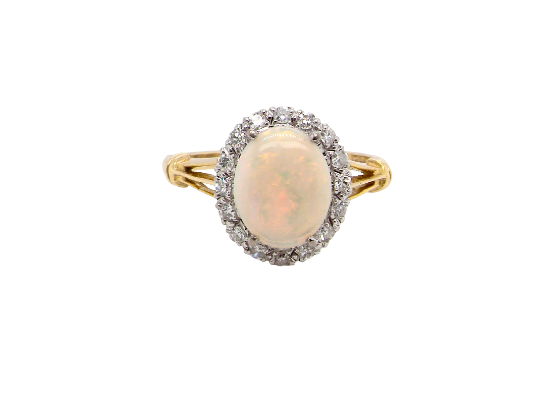 A vintage cluster ring. Features an oval white opal, measures 10x8mm, with a