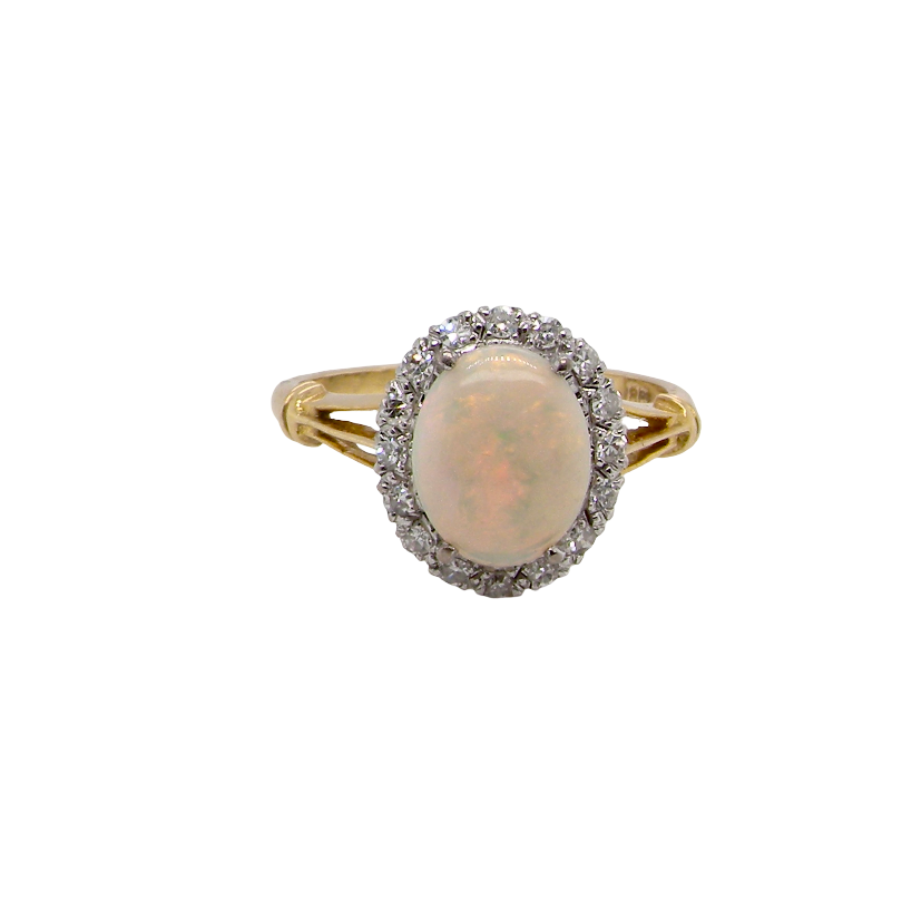 A vintage cluster ring. Features an oval white opal, measures 10x8mm, with a good play of colour.