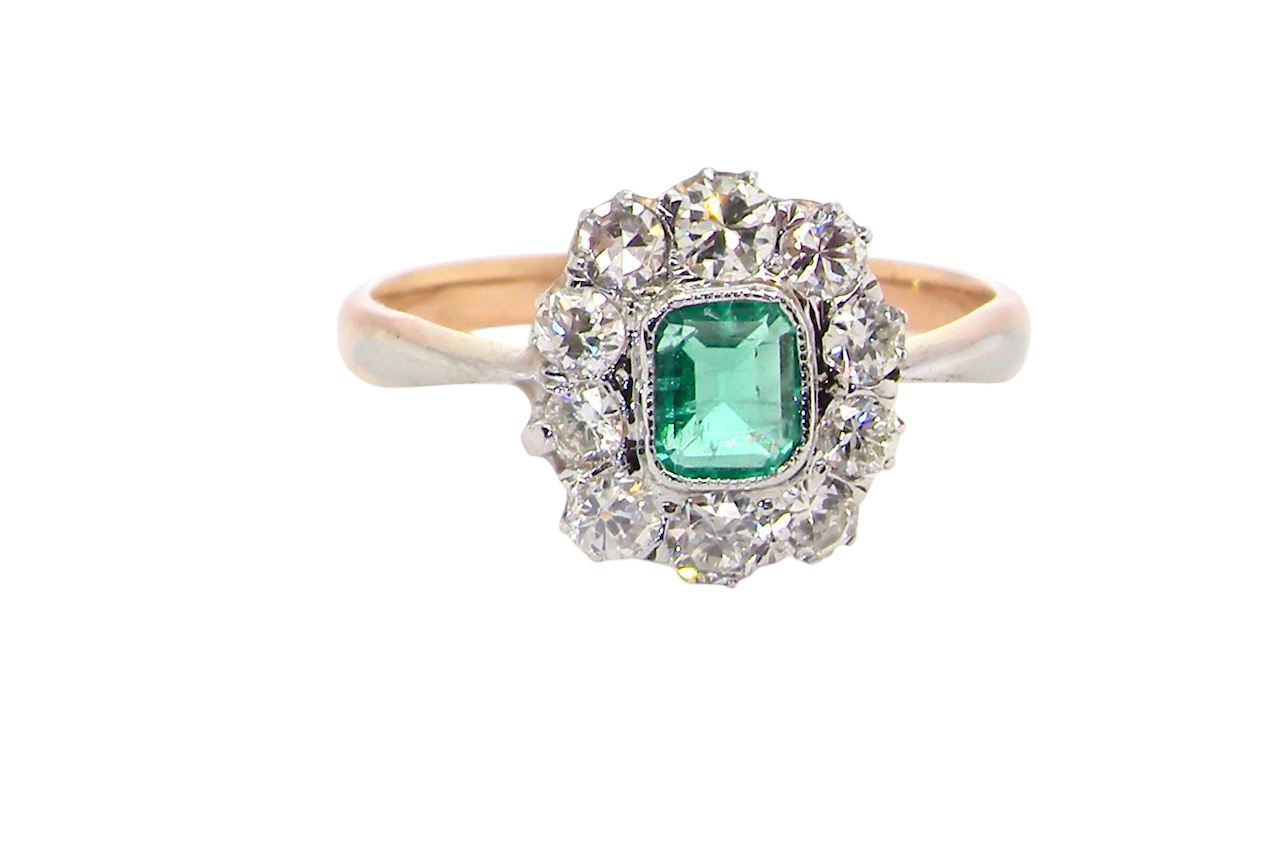 A vintage cluster ring, the centre stone a cushion shaped emerald 4x3.5mm, mid to dark green colour.