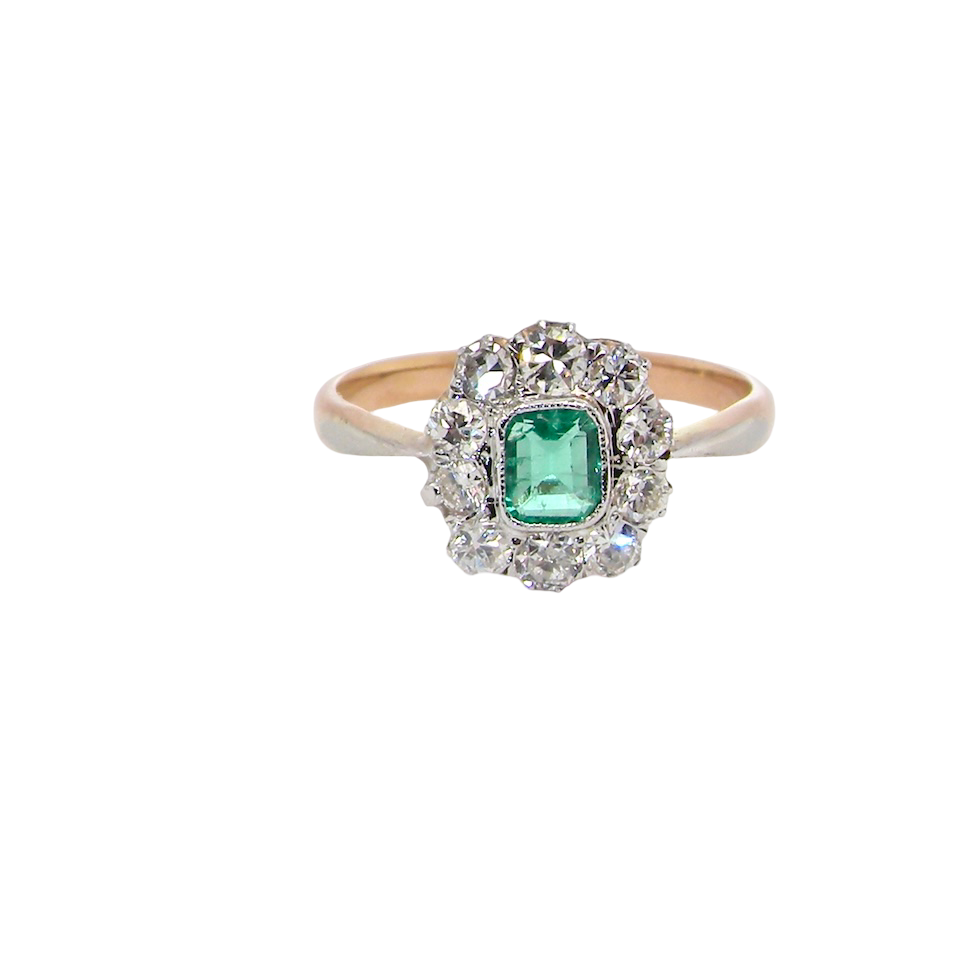 A vintage cluster ring, the centre stone a cushion shaped emerald 4x3.5mm, mid to dark green colour. Mille grain setting.