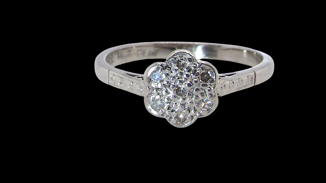 A vintage cluster ring, the head set with seven small single cut white diamonds,