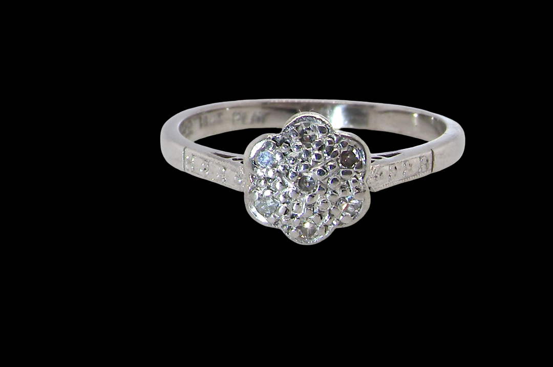 A vintage cluster ring, the head set with seven small single cut white diamonds,