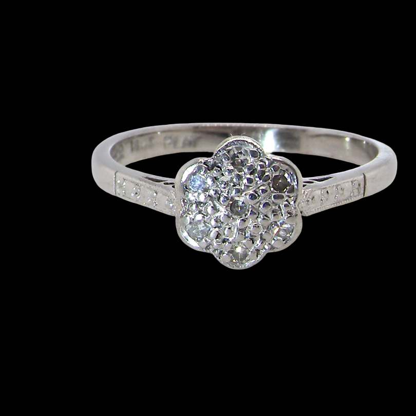 A vintage cluster ring, the head set with seven small single cut white diamonds,