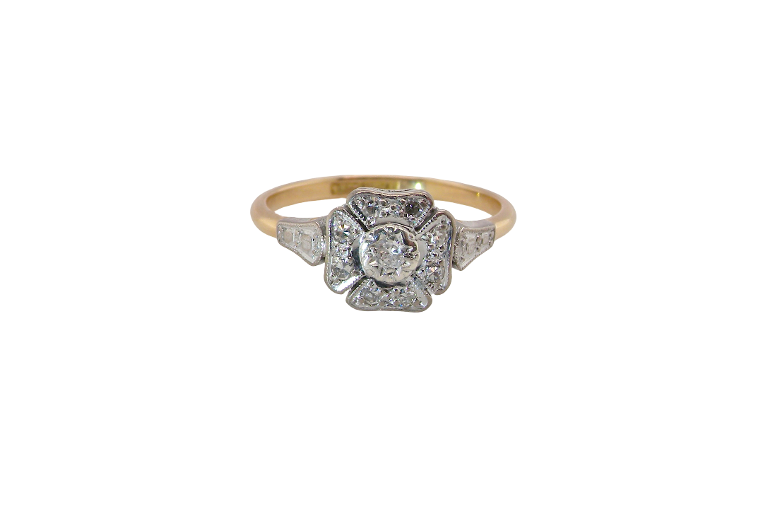 A vintage diamond cluster ring. Shaped like a four leaf clover, each leaf is pavé set with small white diamonds, two each x 1.5mm. Centre diamond 2.4mm. (total estimated total 0.17 carats)