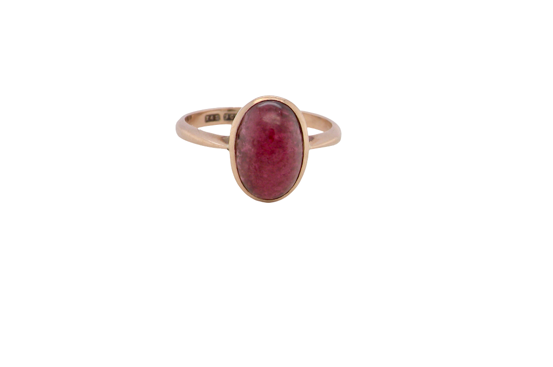 A vintage dress ring. Set with an oval cabouchon cut garnet, 11x7mm, in a rim style setting.