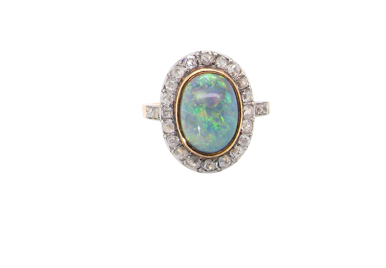 A vintage early 20th century cluster ring. Features to the centre a black opal doublet,