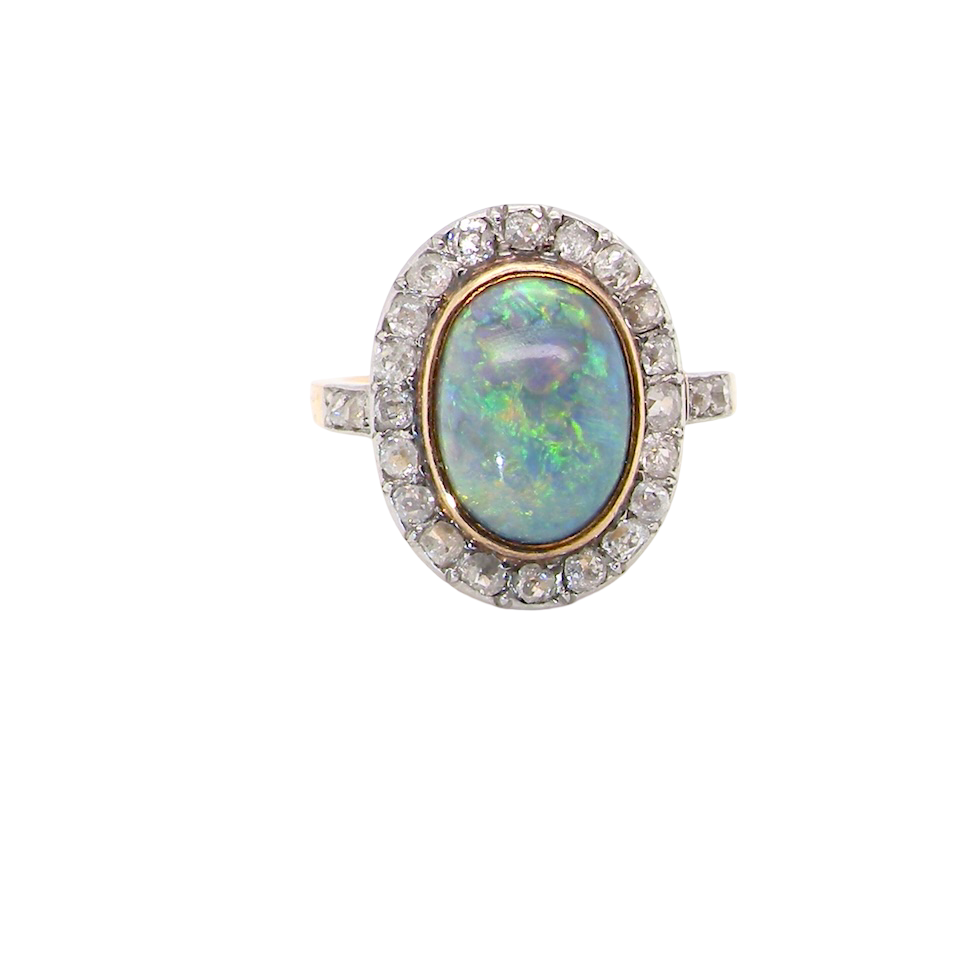 A vintage early 20th century cluster ring. Features to the centre a black opal doublet,