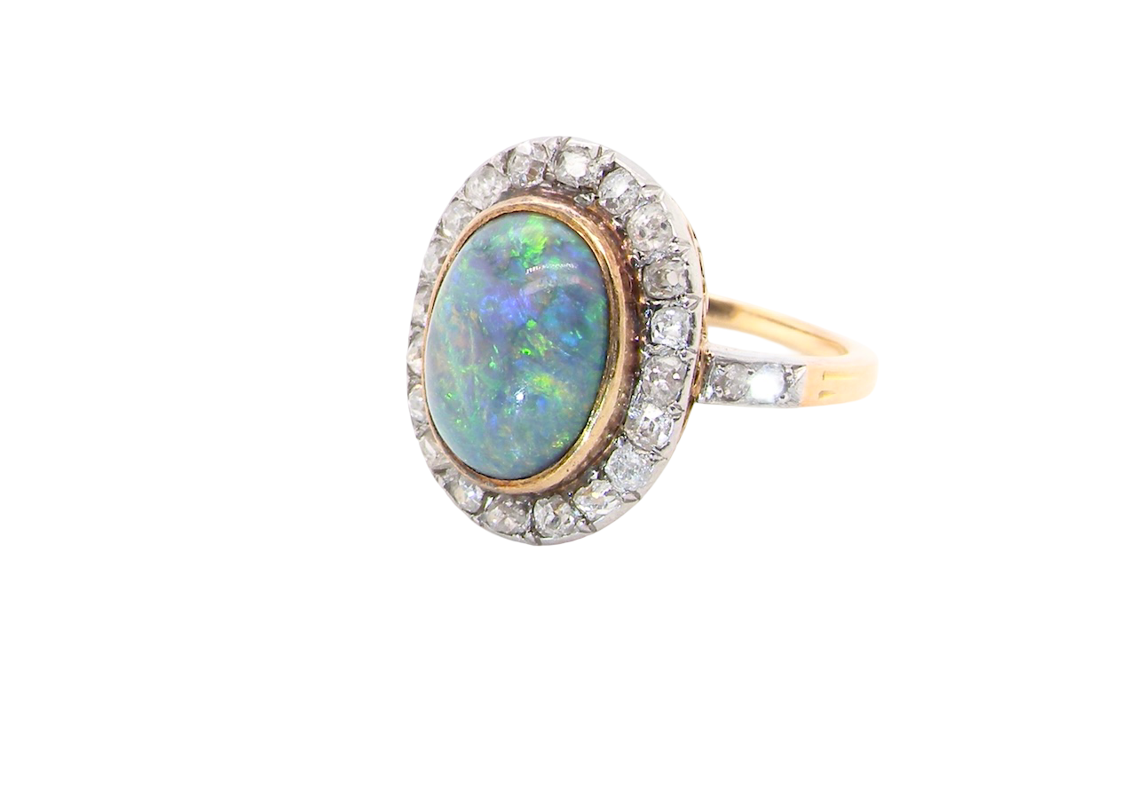 A vintage early 20th century cluster ring. Features to the centre a black opal doublet,
