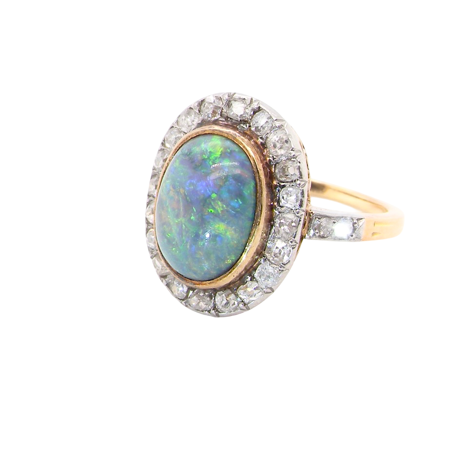 A vintage early 20th century cluster ring. Features to the centre a black opal doublet,
