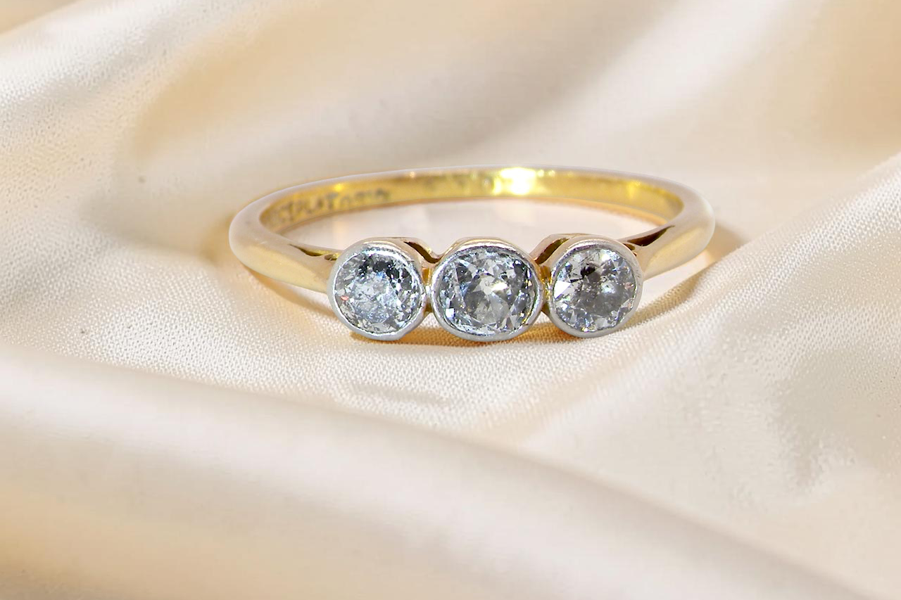 A vintage early 20th century trilogy ring. Set with old cut diamonds, centre stone 3.8mm, and each side a 3.6mm diamond (total carat weight estimated at 0.55 carats)