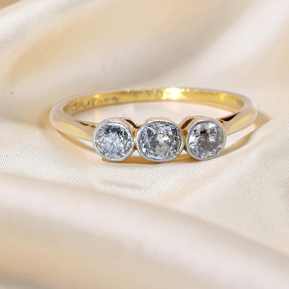 A vintage early 20th century trilogy ring. Set with old cut diamonds, centre stone 3.8mm, and each side a 3.6mm diamond (total carat weight estimated at 0.55 carats)