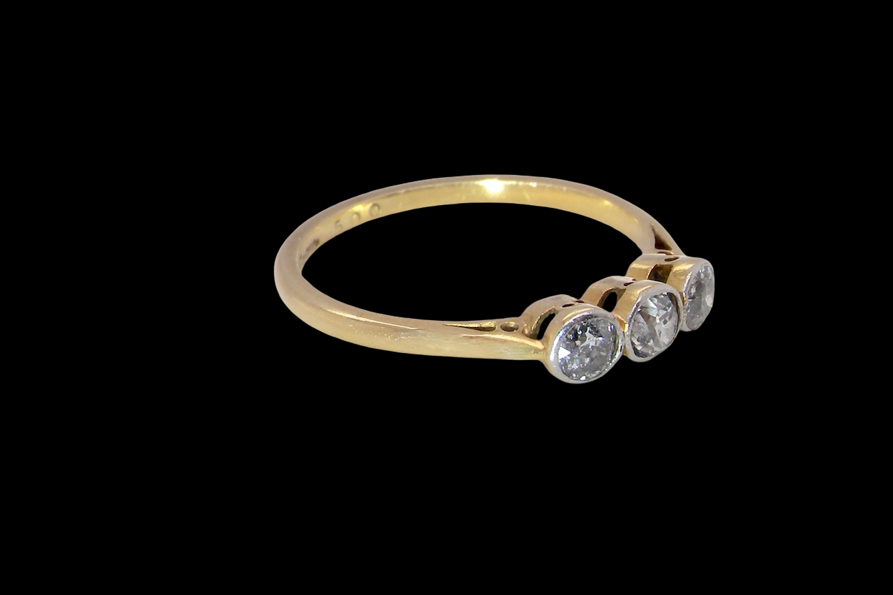 A vintage early 20th century trilogy ring. Set with three old cut diamonds, centre stone 3.8mm, and each side a 3.6mm diamond (total carat weight estimated at 0.55 carats) side
