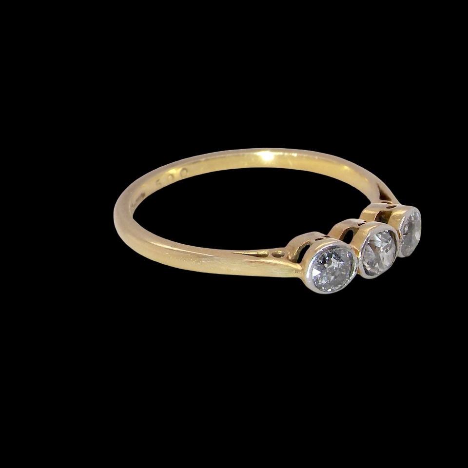 A vintage early 20th century trilogy ring. Set with three old cut diamonds, centre stone 3.8mm, and each side a 3.6mm diamond (total carat weight estimated at 0.55 carats) side