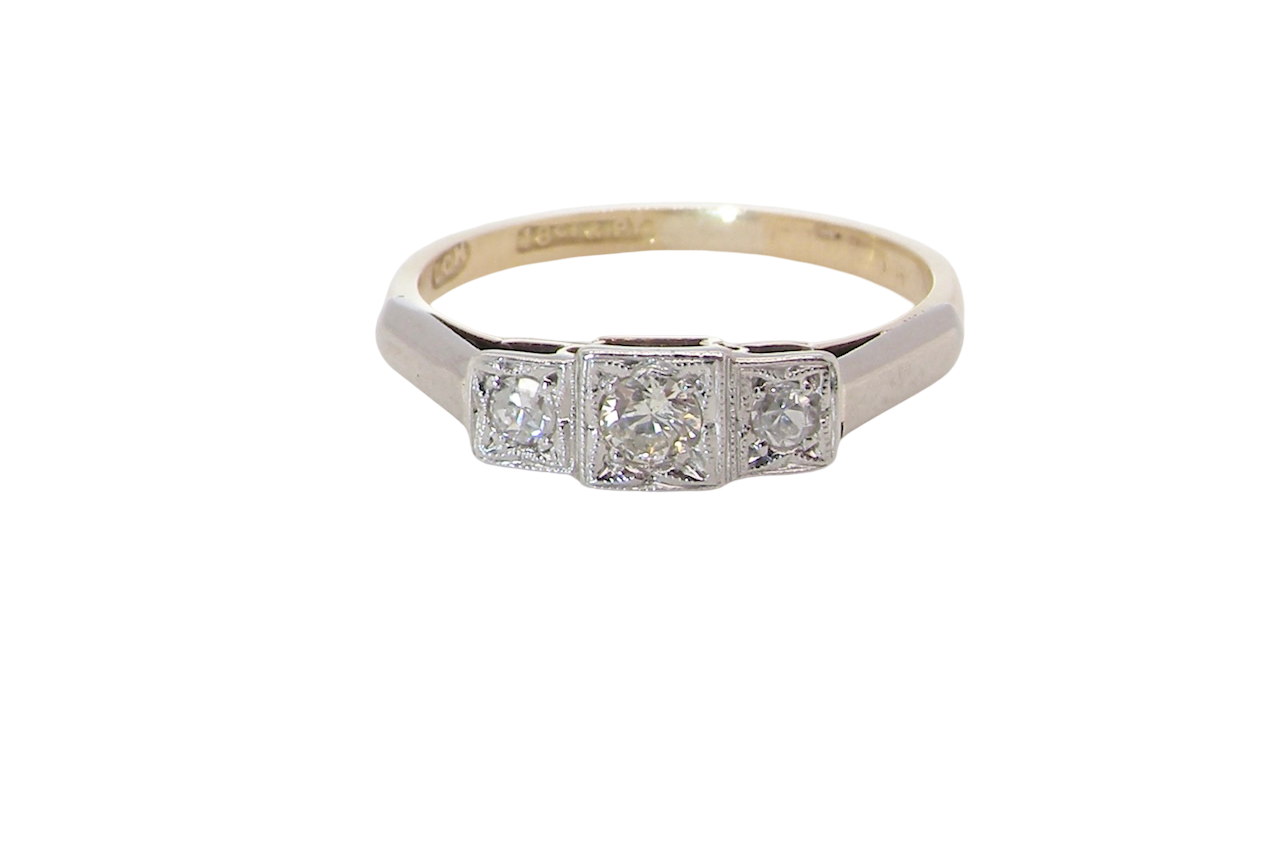 A trilogy ring. Set with three old brilliant cut white diamonds, centre 3mm and each side a 2.4mm diamond. Total estimated at 0.20 carats, colour H-j, clarity Si