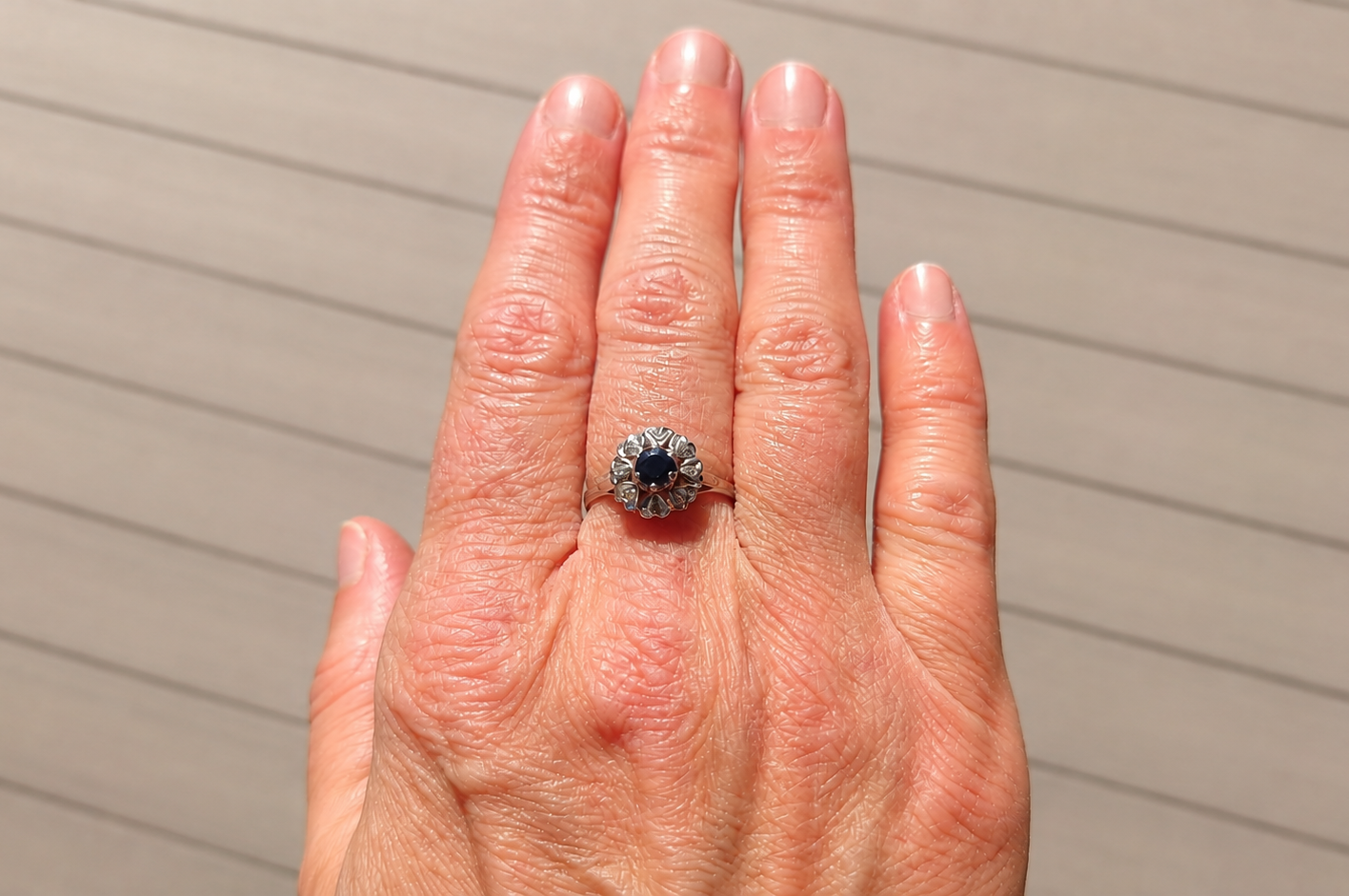 A vintage sapphire cluster ring on a hand