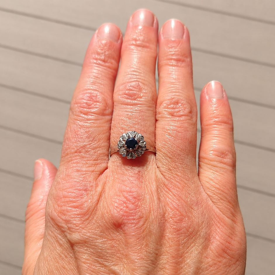 A vintage sapphire cluster ring on a hand