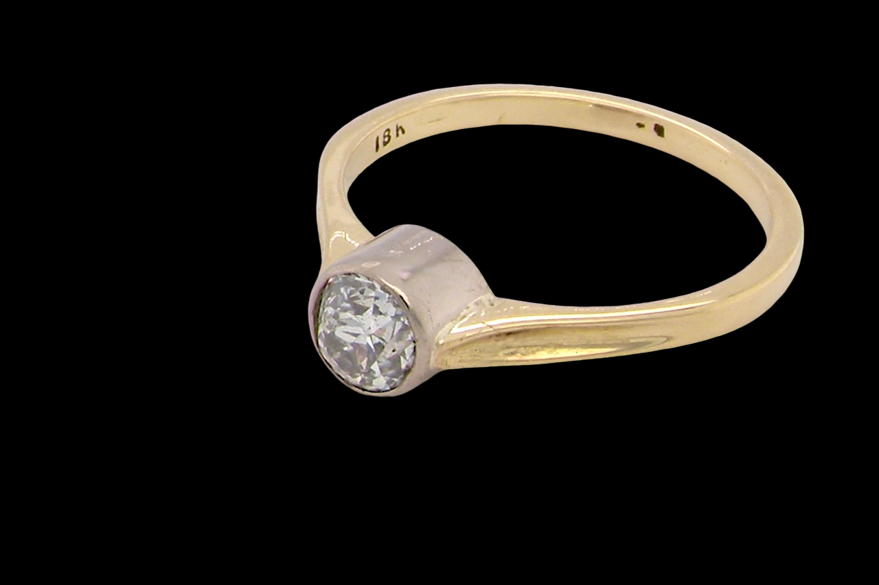 Gold ring with a diamond on a black background