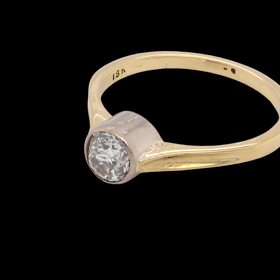 Gold ring with a diamond on a black background