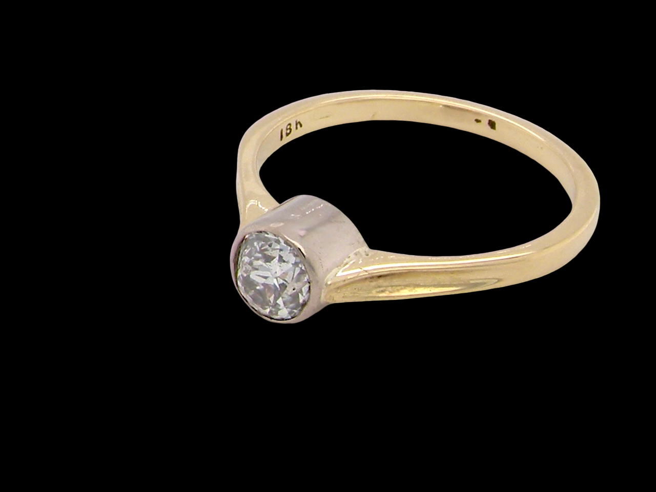 Gold ring with a diamond on a black background
