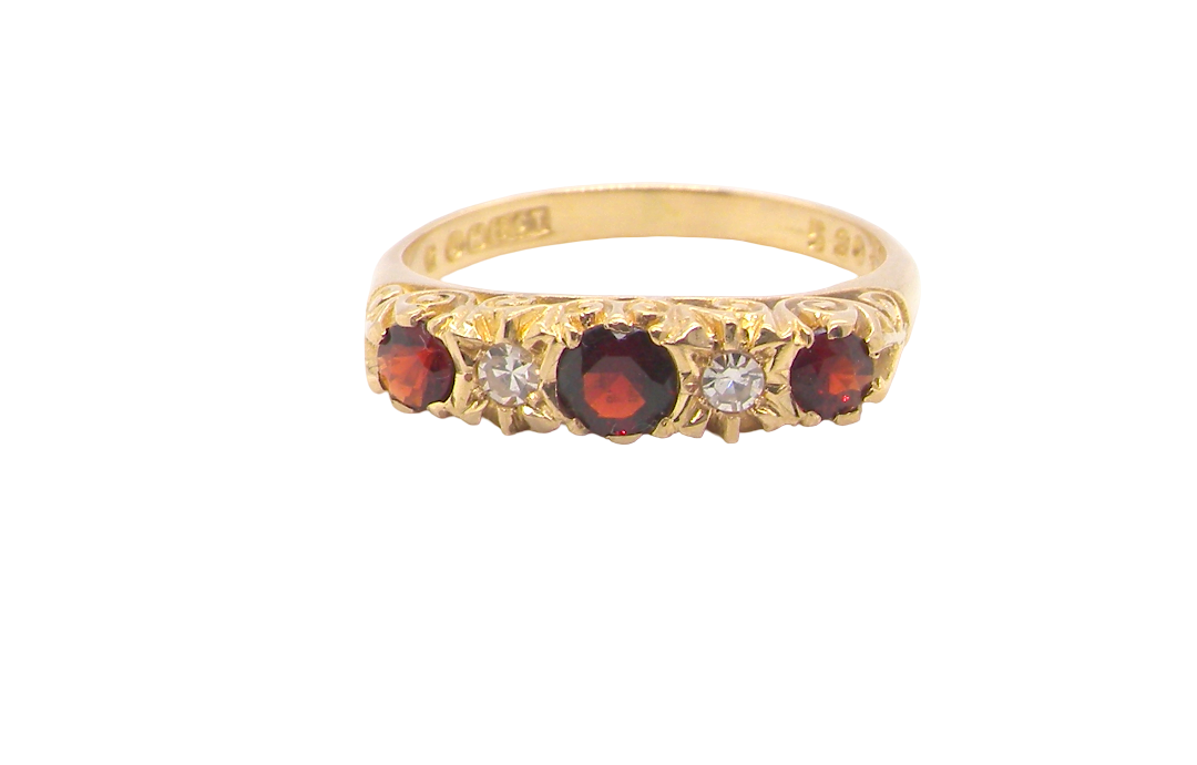 A vintage style 18 carat gold boat shaped ring. Features three dark red garnets, centre 4mm, each end a 3mm stone. 