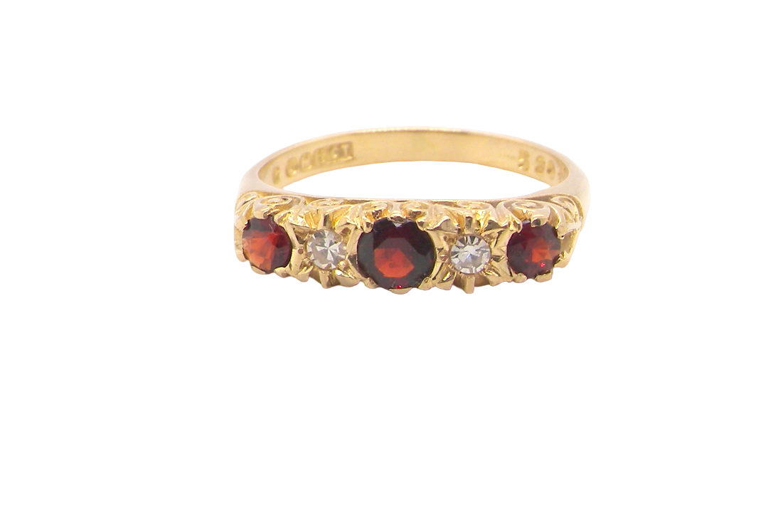 A vintage style 18 carat gold boat shaped ring. Features three dark red garnets, centre 4mm, each end a 3mm stone. 