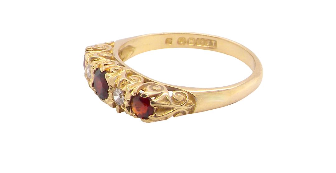 A vintage style 18 carat gold boat shaped ring. Features three dark red garnets, centre 4mm, each end a 3mm stone.
side
