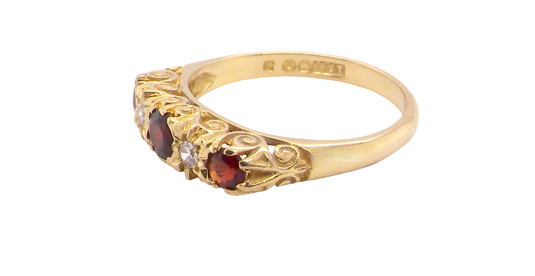 A vintage style 18 carat gold boat shaped ring. Features three dark red garnets, centre 4mm, each end a 3mm stone.
side